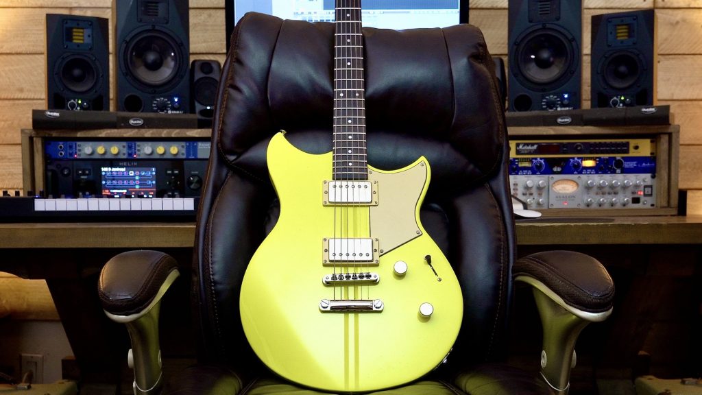 Striking neon yellow electric guitar propped on leather chair with sound studio in background.