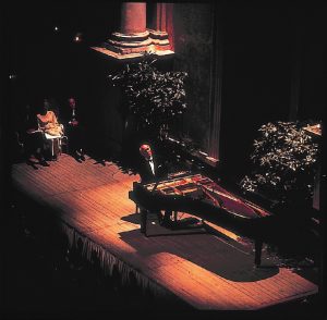 A man playing a piano on a concert stage.