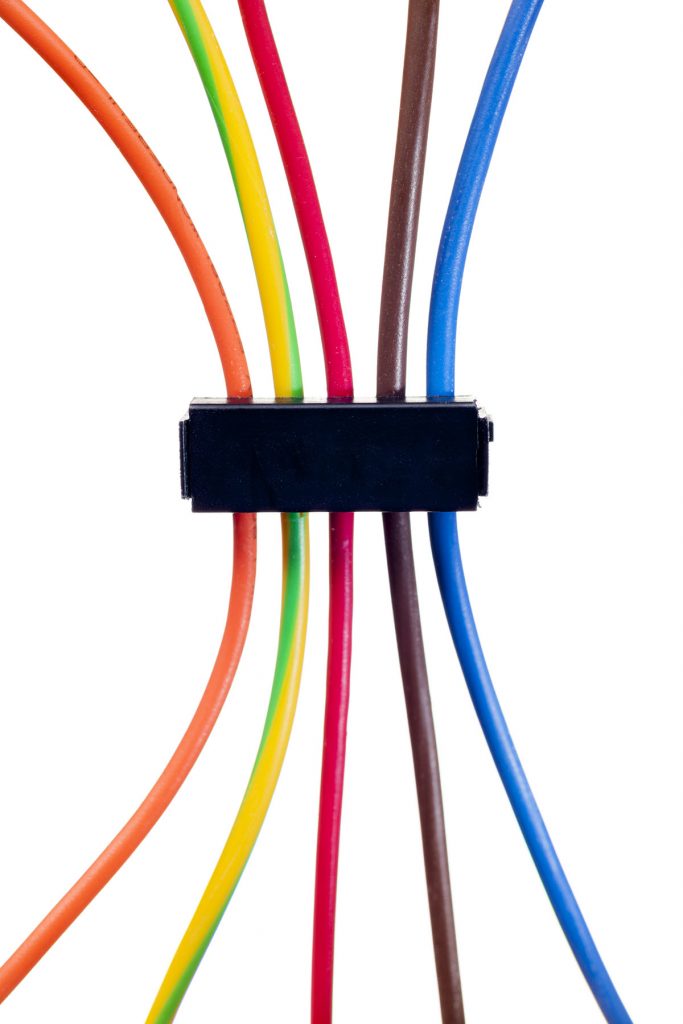 Five wires of different colors channeled through a bar style cable clip.