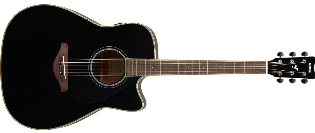 An acoustic guitar with knobs on side of body.