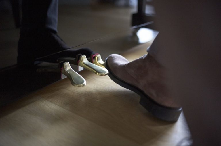 Closeup of a booted foot using the right-handed piano pedal.