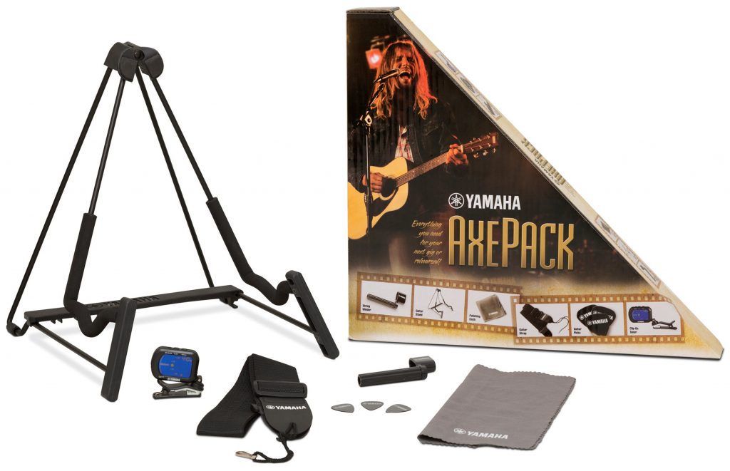 A triangular shaped "Axe Pack" guitar accessories box with the contents distributed in front of it.