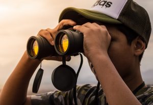 male looking through binoculars