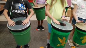 several students playing bucket drums