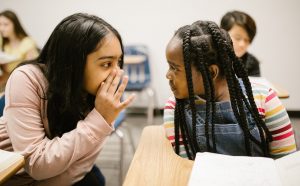 two female students talking to each other in classroom