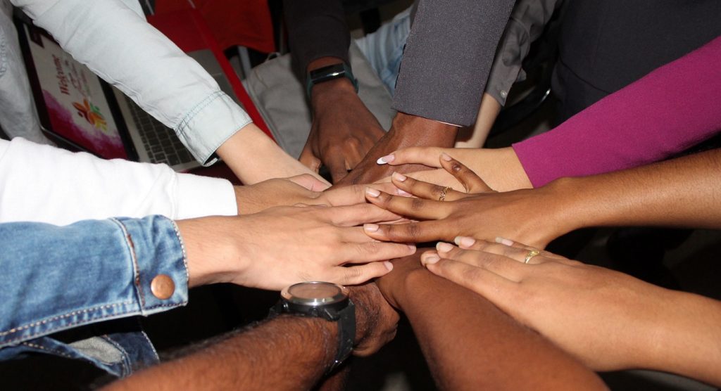 group pf students with hands stacked on top of each other