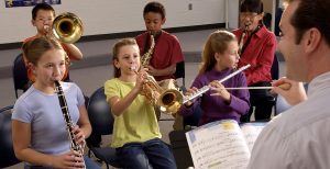 male music teacher conducting middle school band