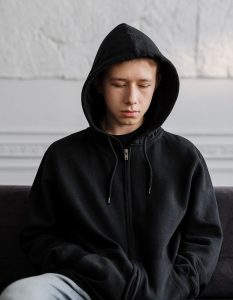 upset male teen with hoodie on