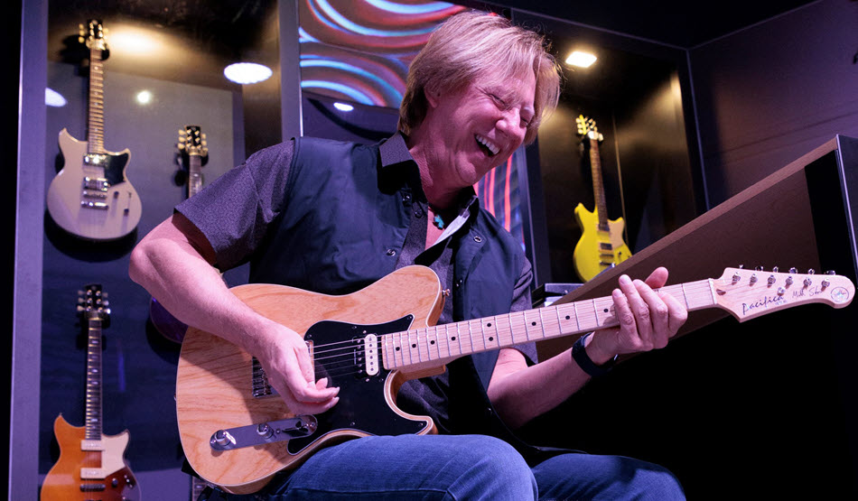 Author smiling and laughing while playing guitar.
