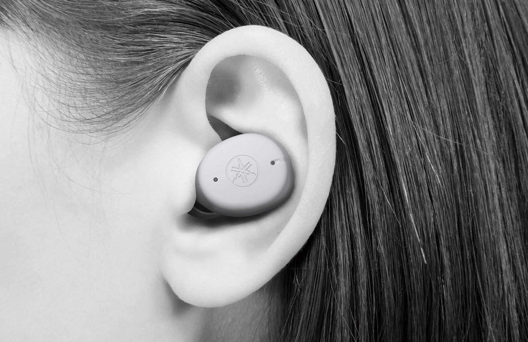 Closeup of a person's ear with an ear bud in it.