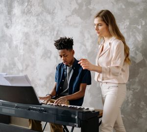 female piano teacher with male student