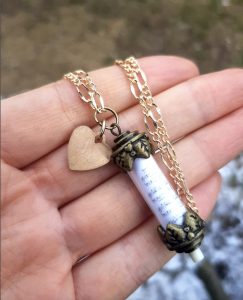 hand holding music-themed necklace