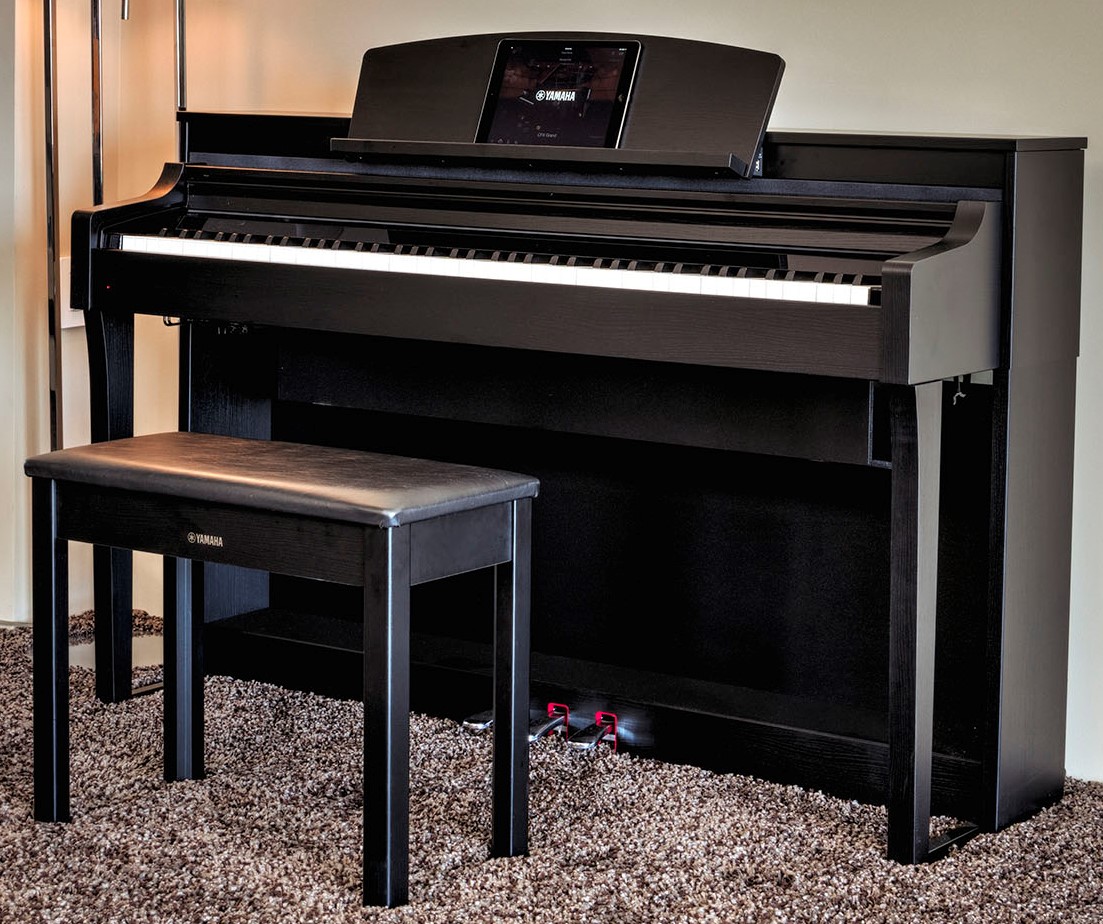 Upright digital piano and bench in a living room.
