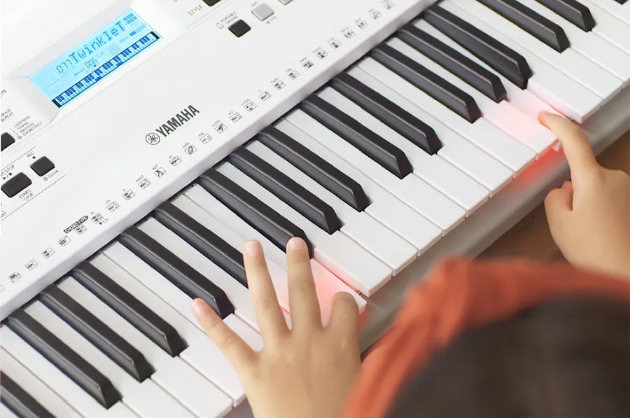 Closeup of child's hands playing electronic keyboard.