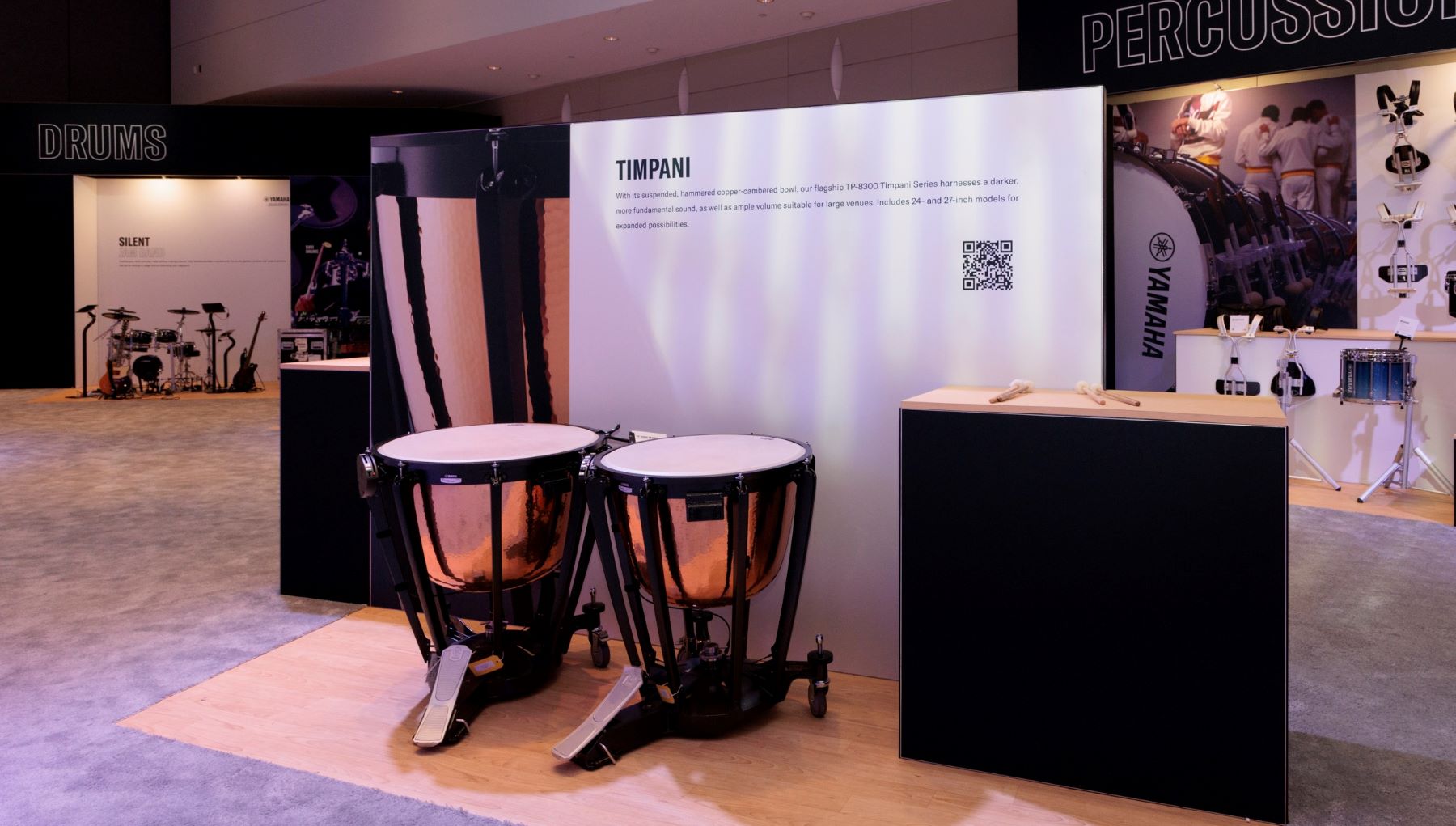 Display with two timpani drums in front of signage.