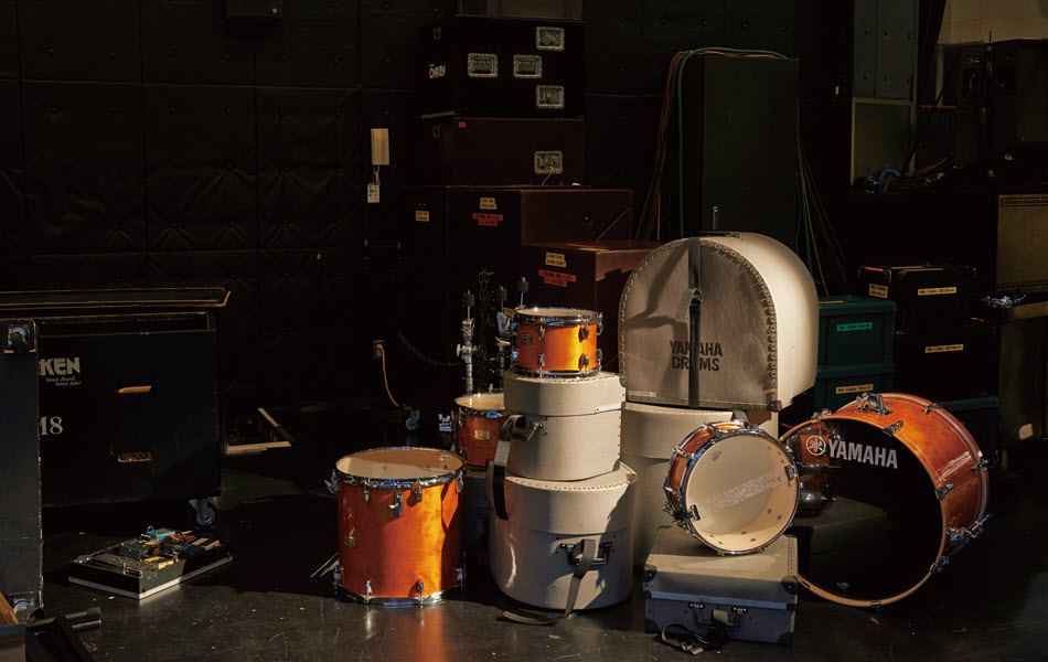 Stack of drums on darkened stage.