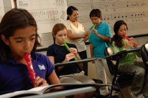students in classroom playing recorders
