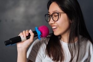 teen holding mic and singing