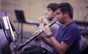 two male music students, one playing the flute, the other the oboe