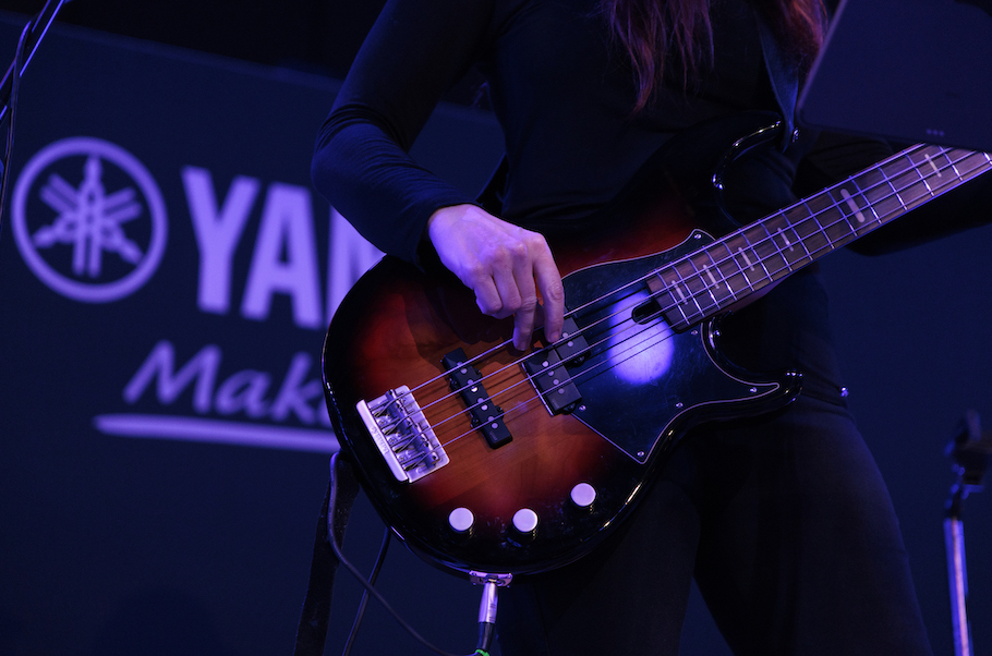 Closeup of Yamaha bass guitar being played.