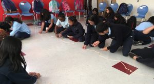 students working on creating soundwaves with popsicle sticks