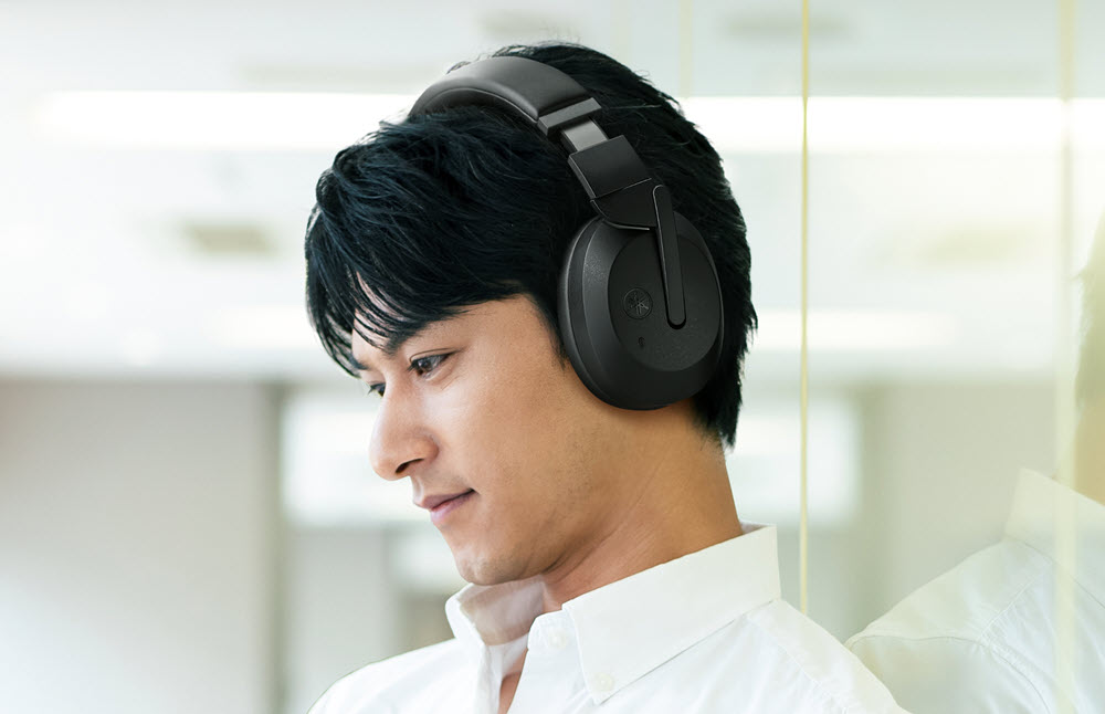 Man seen in profile wearing over head headphones.