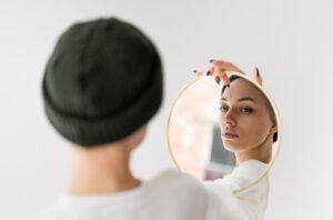 woman looking at herself in a handheld mirror