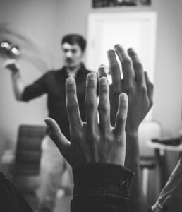 two students hold hands up in class