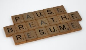 letter tiles that spell out "Pause, Breath, Resume" 