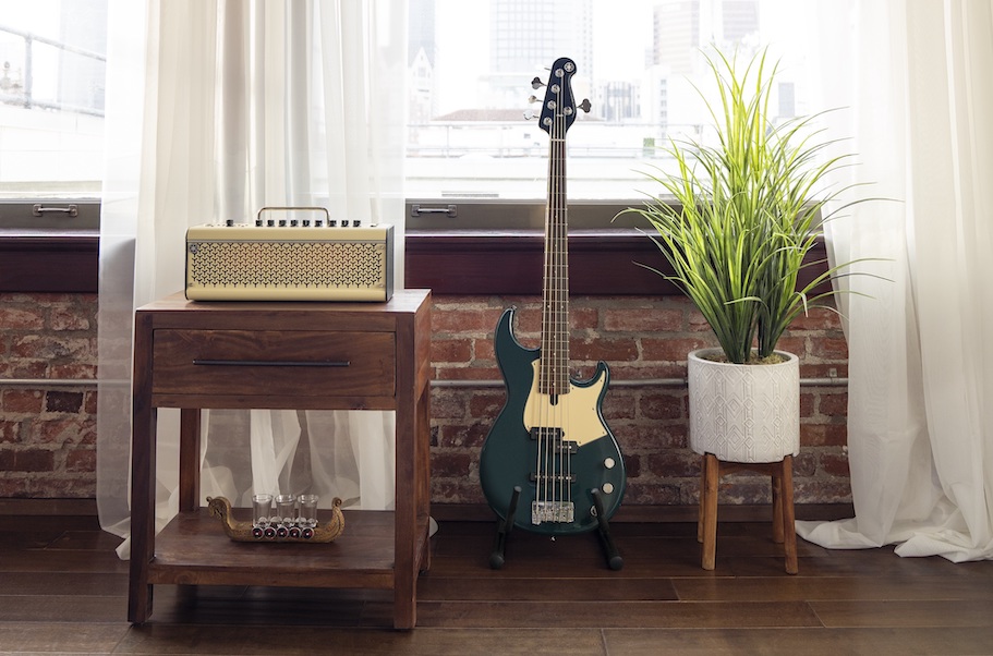 Electric bass with small amplifier in a living room.