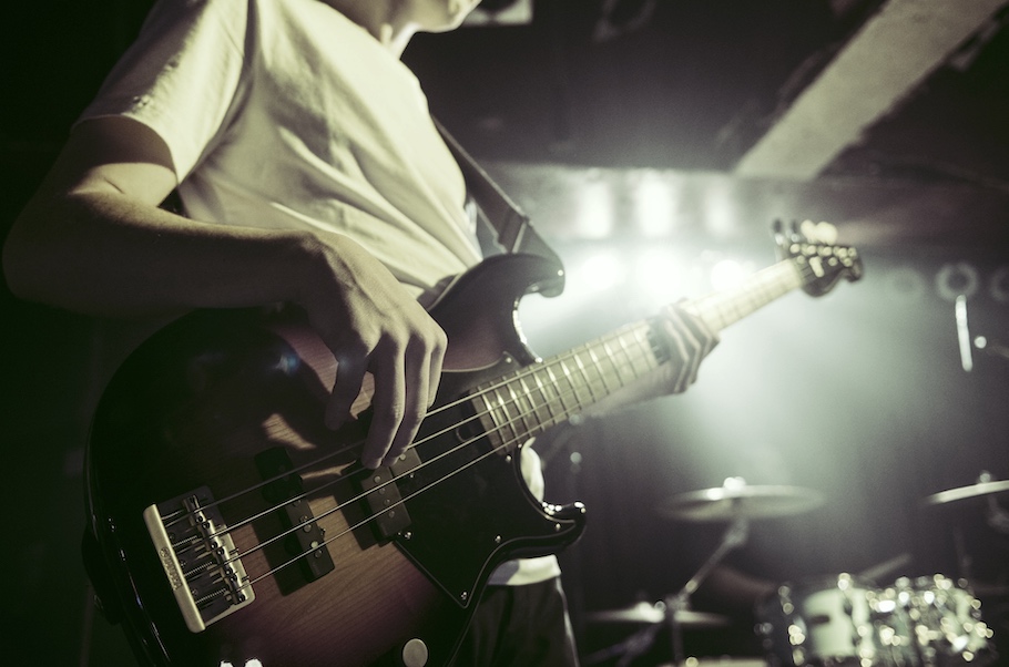 Closeup of someone playing bass guitar.