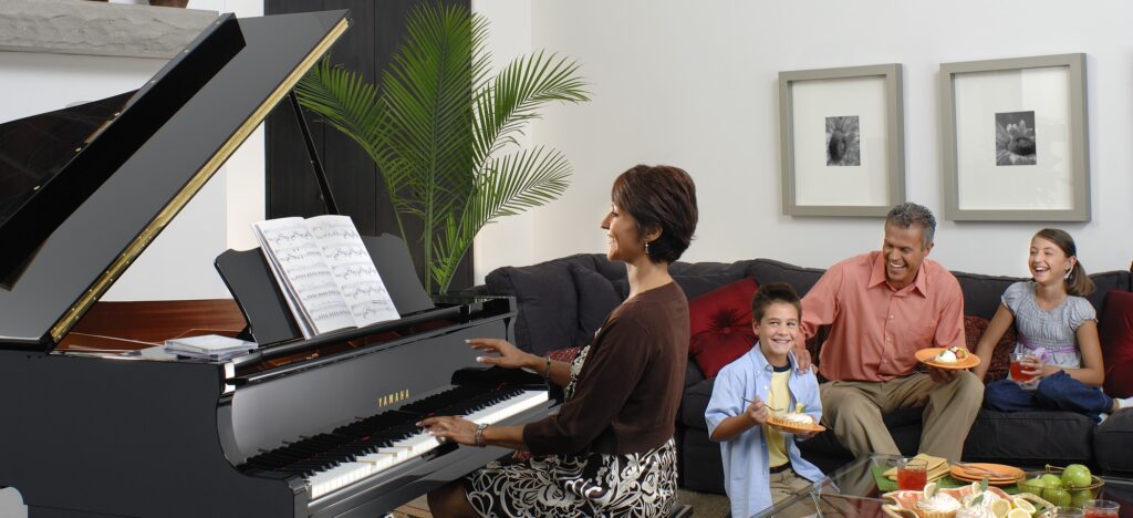 A woman playing piano in front of her family.