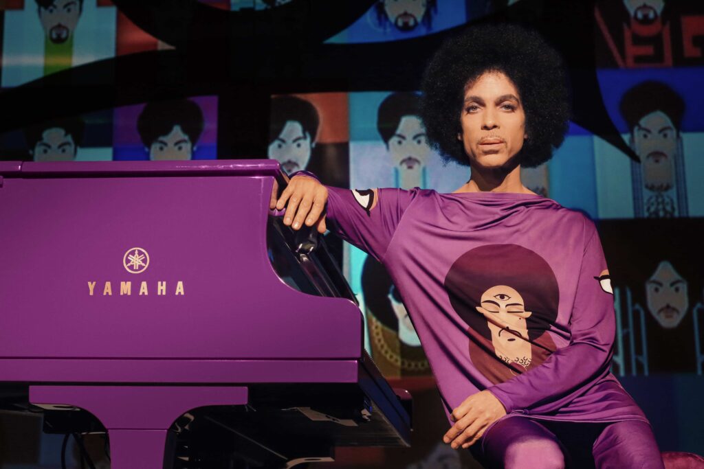 Prince sitting at his purple piano.