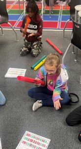 two students using boomwhackers
