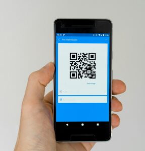 hand holding phone with QR code on screen