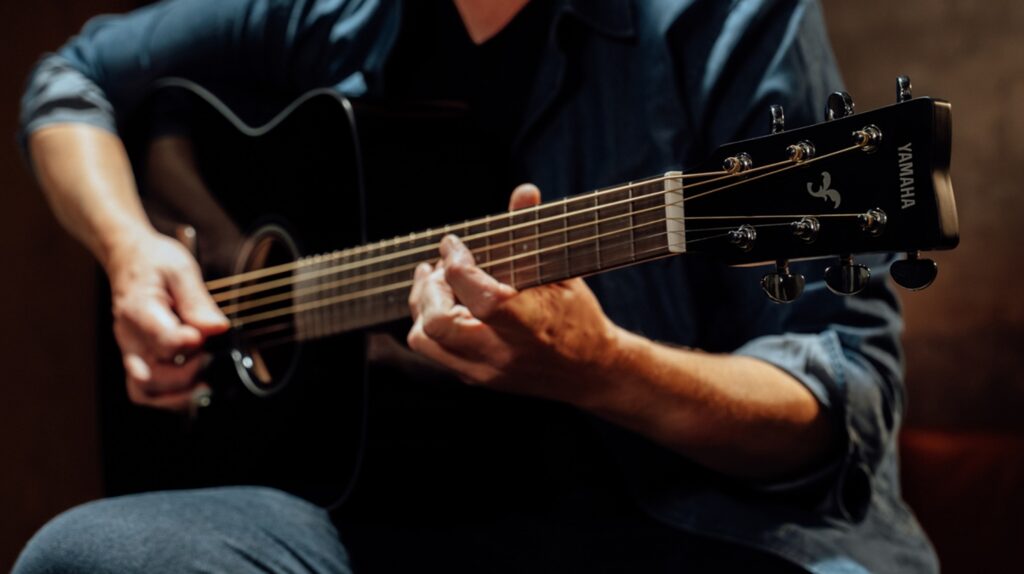 closeup of someone playing acoustic guitar