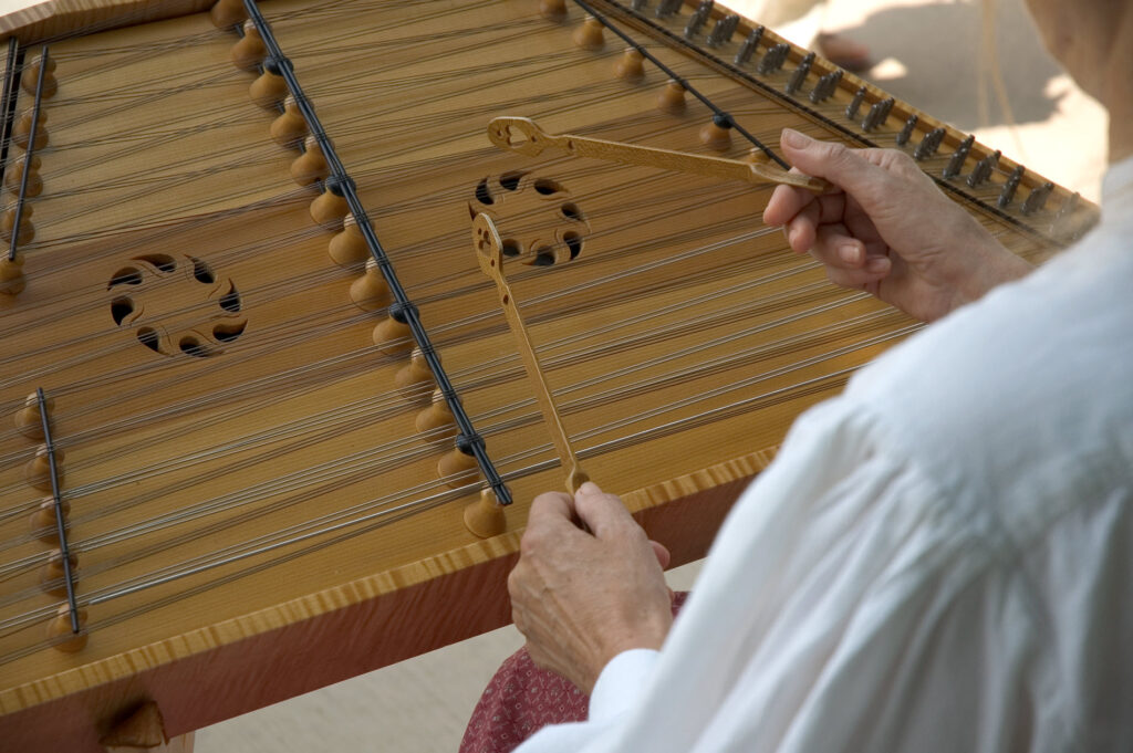 Stringed instrument being played with small mallets.