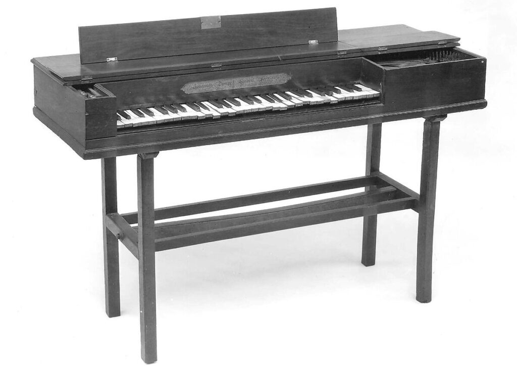 A rectangular piano on four legs.