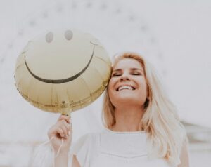happy woman holding a balloon with happy face