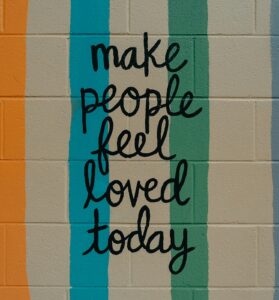 "make people feel loved today" painted on wall