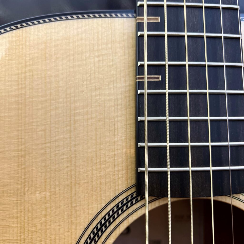 Fretboard of acoustic guitar where it meets the body.
