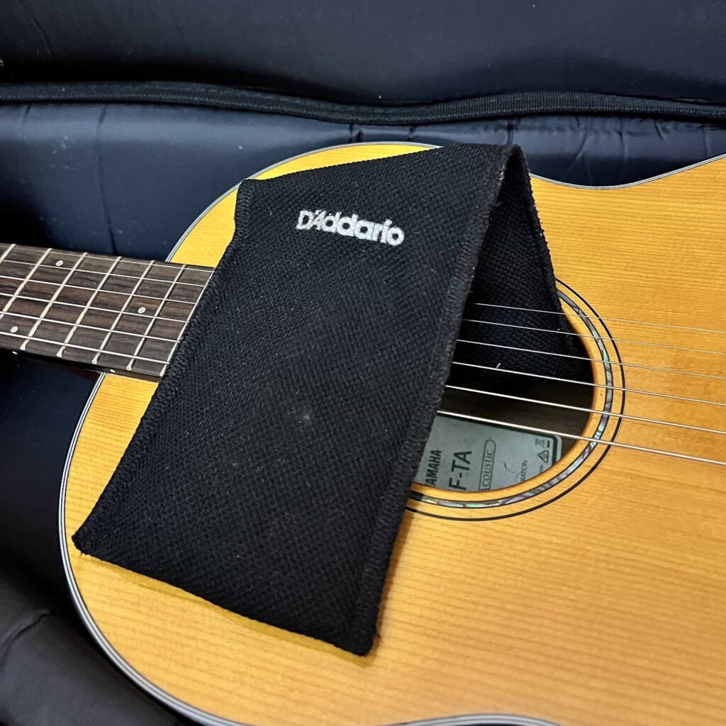 A Humidipak hanging over an acoustic guitar sound hole.