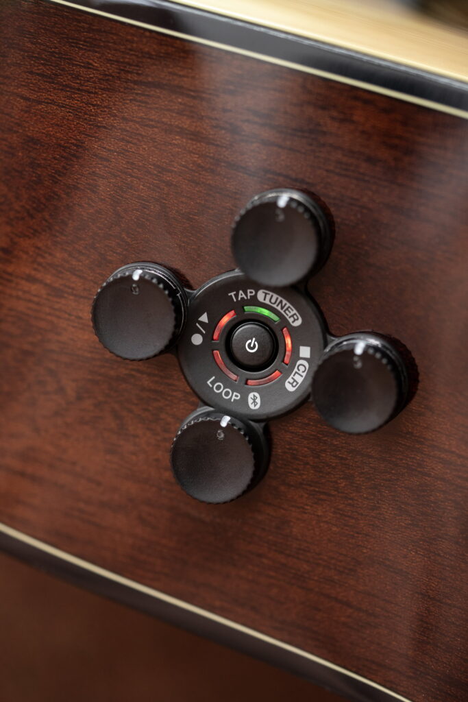 A series of small knobs on the top of an acoustic guitar.