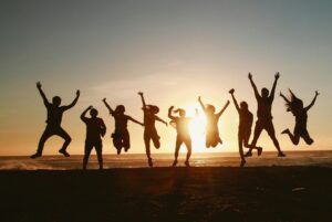 silhouette of a group of students jumping for joy at sunset