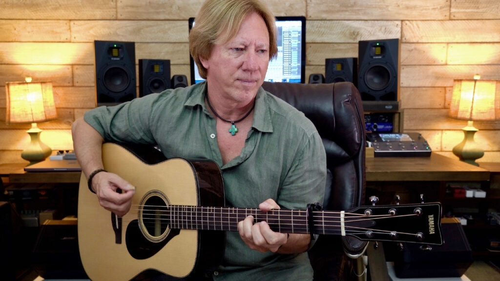 A man playing an acoustic guitar.