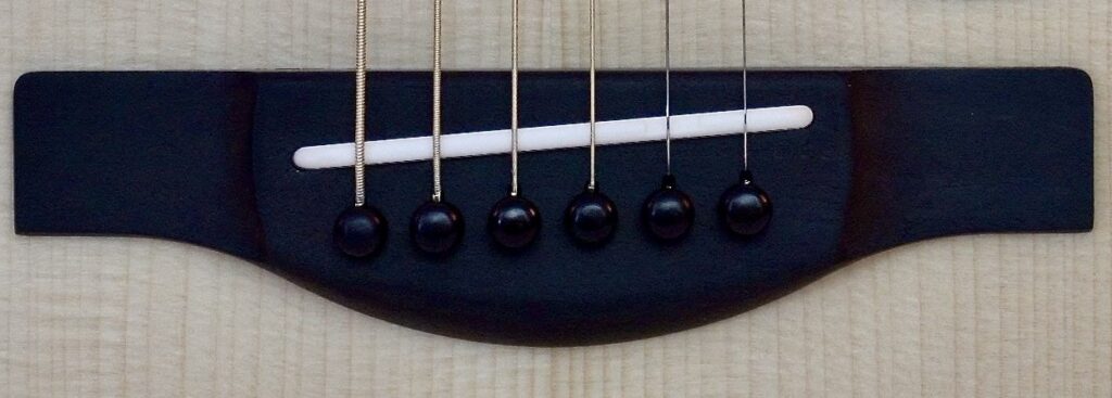 An acoustic guitar bridge and saddle.