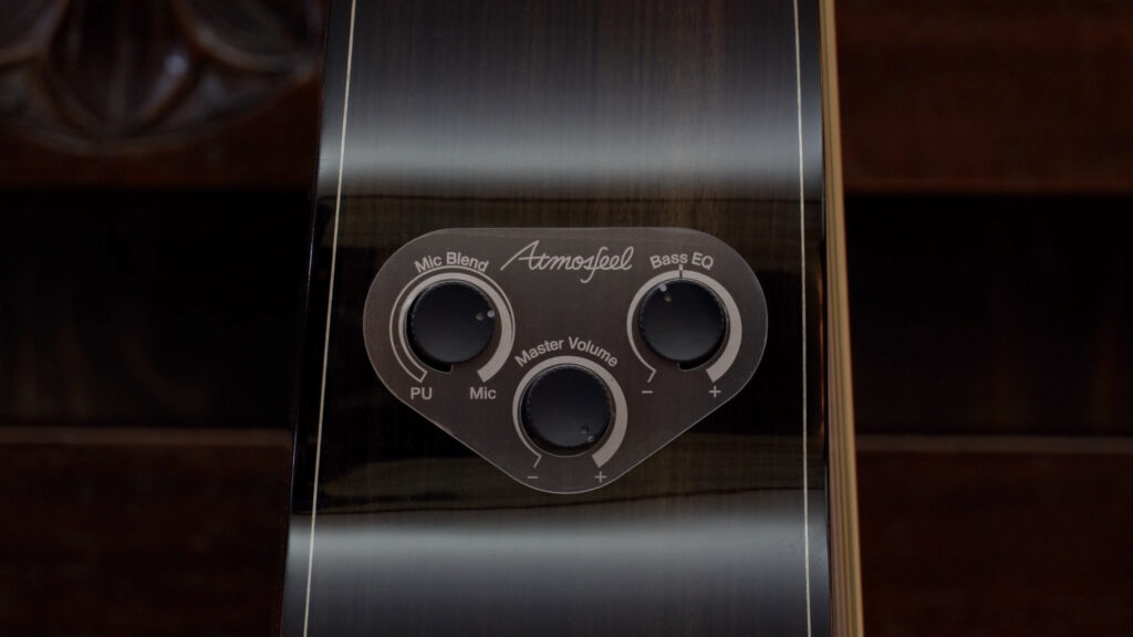 Three rotary dials on the top of an acoustic guitar.