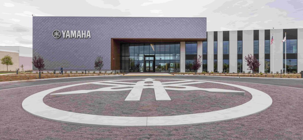 A circular driveway outside an office building with an image of a tuning fork in a circle.