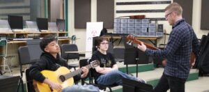 music educator with guitar students
