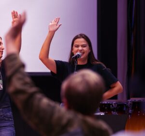 music educator holding up her had in front of class
